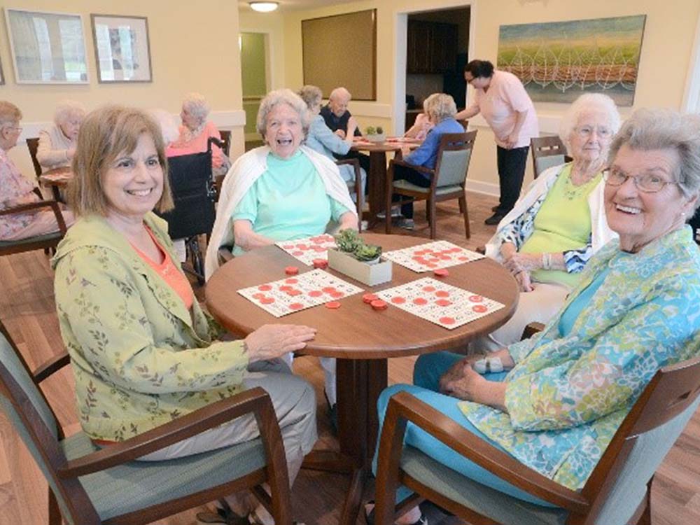 residents play bingo while smiling at the camera