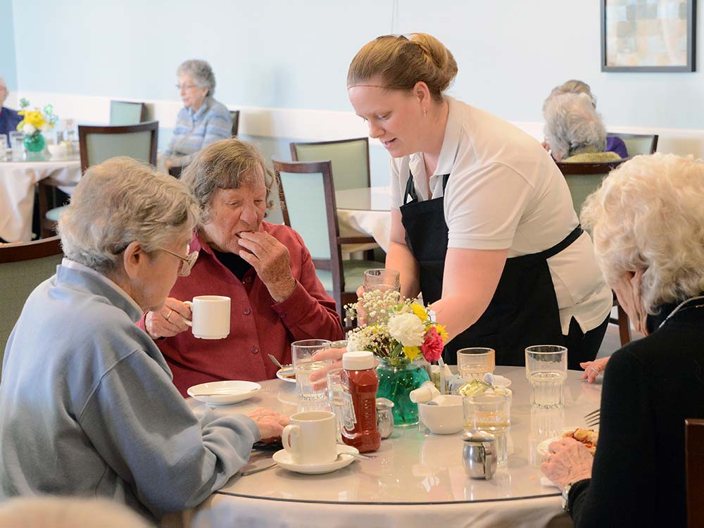 staff serving residents in dining room