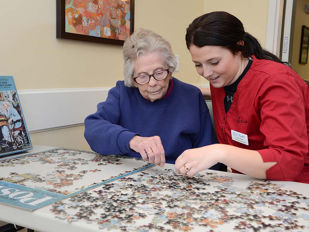 resident and nurse put a puzzle together