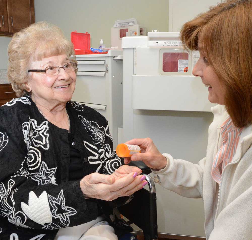 woman is handed a pill to take