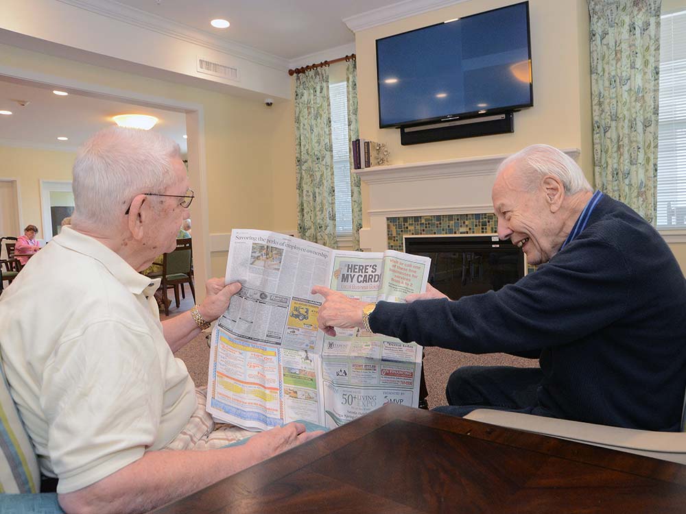 2 residents share a newspaper